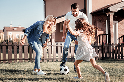 Family playing soccer outdoors